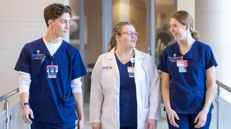 Female faculty discussing something with two nursing 学生s.